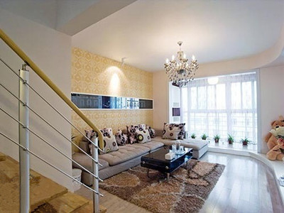 装修选用白杉木强化地板,客厅沙发区,米黄色的壁纸铺成温馨的沙发背景